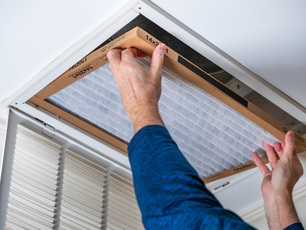 HVAC technician replacing a home air filter in Rancho Santa Margarita